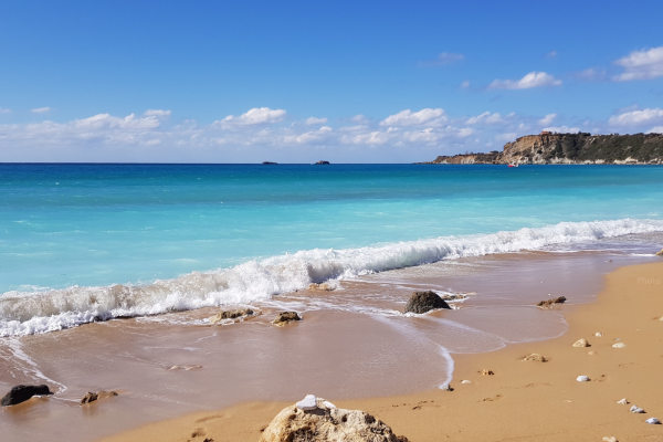 A turquoise blue sea and golden sand at Avithos Beach in Kefalonia, Greece